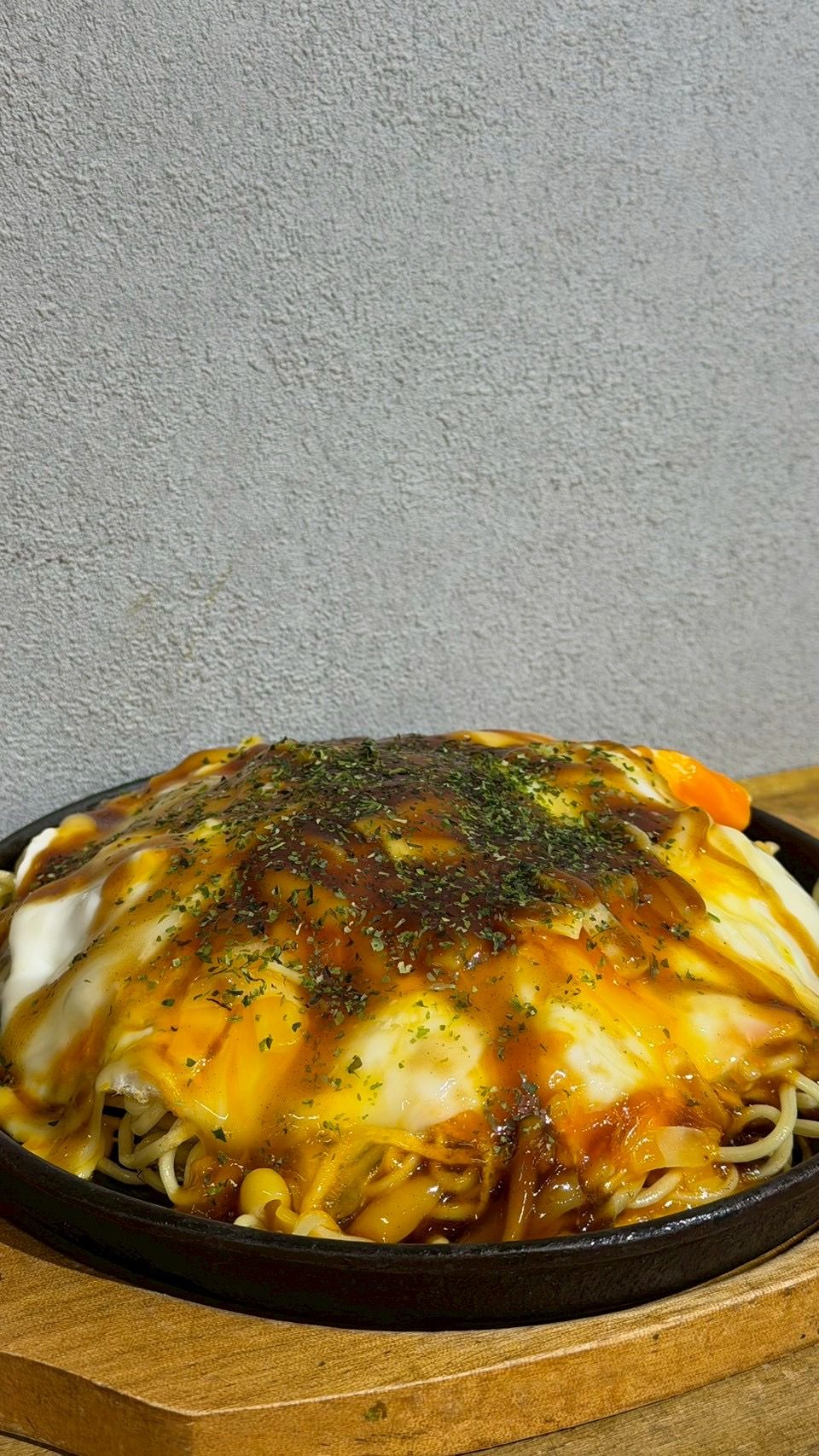 鉄板皿にのせたmukkuの関西風お好み焼き